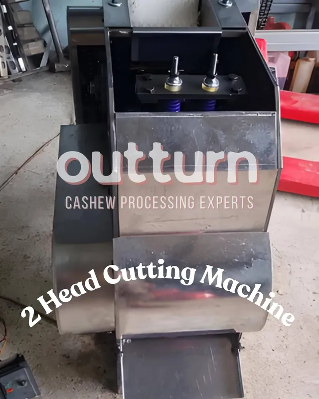 OUTTURN 2-head cashew cutting machine showing twin stainless steel cutting cups and blade assembly