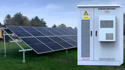 Solar panel array beside a rural cashew processing shed, wired to cutting machines and lighting