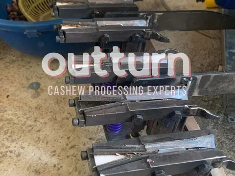 Shelves of genuine OUTTURN cashew cutting machine spare parts including blades, cutting cups and blade assemblies