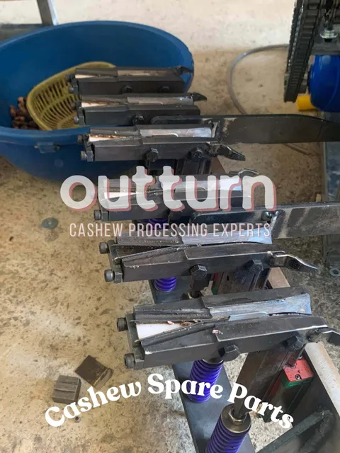 Shelves of genuine OUTTURN cashew cutting machine spare parts including blades, cutting cups and blade assemblies